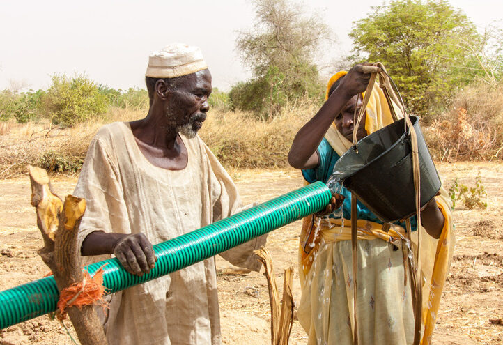 Man and woman in Sudan watering agriculture