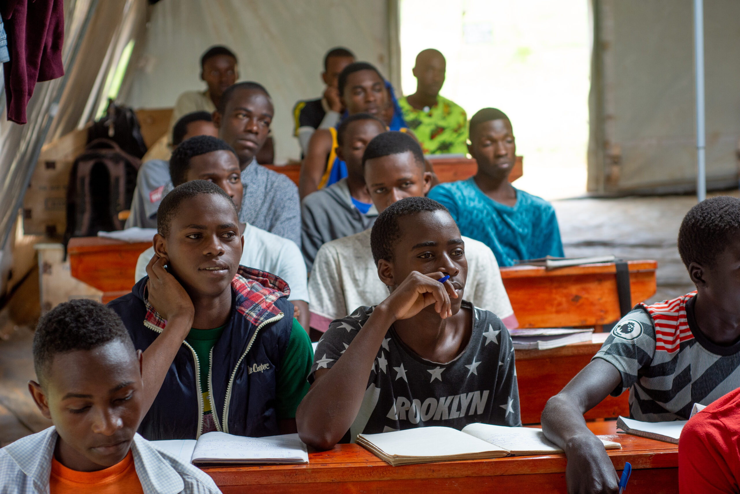 Boys attend class in a temporary learning space in Uganda